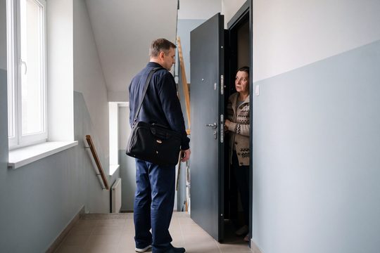 Лікар із медичною сумкою біля дверей квартири
